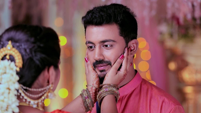 A Still Of Kamali Holding Rishi's Face